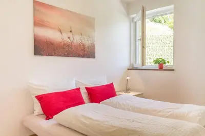 a bedroom with a bed with red pillows on it at Goldenhof Penon in Penone