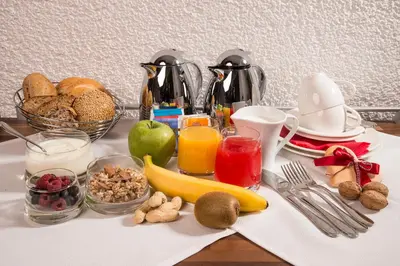 a breakfast table with breakfast foods and fruits and juice at Alpin Sport in Ortisei