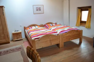 a large wooden bed in a room with a wooden floor at Gruberhof in San Genesio Atesino