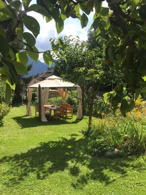 a gazebo with a table and bench in a yard at Casa Gianmoena in Cavalese