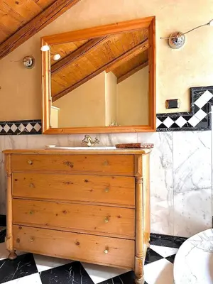 a bathroom with a wooden dresser and a mirror at Casa Gianmoena in Cavalese