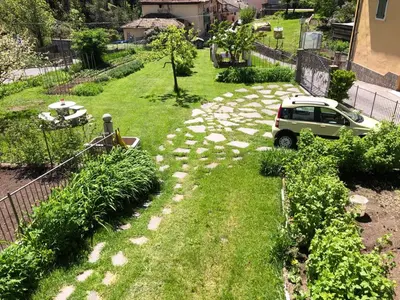 a car parked in a yard with a stone path at Casa Gianmoena in Cavalese