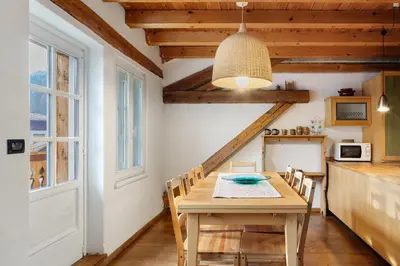 a dining room with a table and a kitchen at La Casa del Noce in Fiera di Primiero