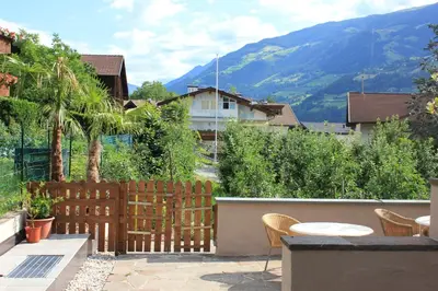 a patio with a fence and a table and chairs at Kehrerhof in Rifiano