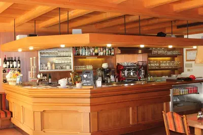 a bar in a restaurant with a wooden counter at Kehrerhof in Rifiano
