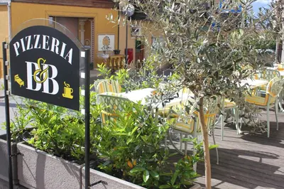 a sign for a restaurant with a table and chairs at Kehrerhof in Rifiano
