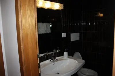 a bathroom with a sink and a toilet and a mirror at Kehrerhof in Rifiano