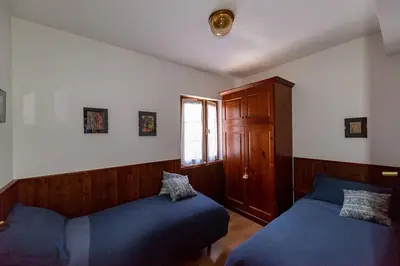 a bedroom with two beds and a window at Appartamento centralissimo con wi-fi in Cortina dʼAmpezzo