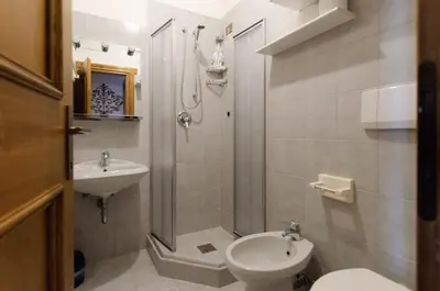 a bathroom with a shower and a toilet and a sink at Appartamento centralissimo con wi-fi in Cortina dʼAmpezzo