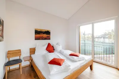 a bedroom with a bed with white sheets and red pillows at Ferienhaus im Grünen in Terlano
