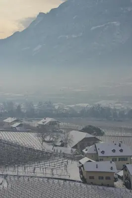 a farm with a snow covered field and a mountain at Ferienhaus im Grünen in Terlano