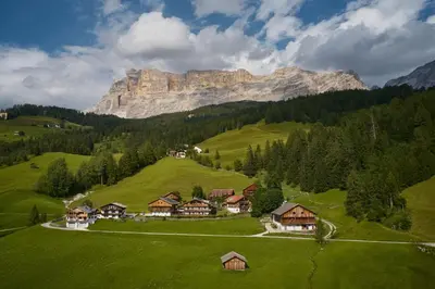 a village on a hill with a mountain in the background at Residence Rosarela in Badia