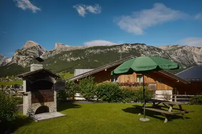 a picnic table and an umbrella in front of a building at Residence Rosarela in Badia