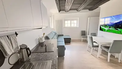 a kitchen and living room with a couch and a table at Bolzano 2-Room Central Mountain View, WiFi Netflix AC Lift in Bolzano