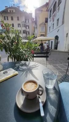 a cup of coffee sitting on top of a table at Bolzano 2-Room Central Mountain View, WiFi Netflix AC Lift in Bolzano