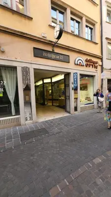 a store front of a building with a clock on it at Bolzano 2-Room Central Mountain View, WiFi Netflix AC Lift in Bolzano