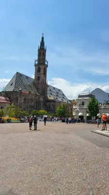 a large building with a clock tower in a plaza at Bolzano 2-Room Central Mountain View, WiFi Netflix AC Lift in Bolzano