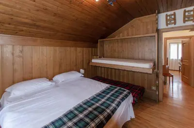 a bedroom with a bed in a wooden room at Spazioso appartamento centrale con wi-fi in Cortina dʼAmpezzo