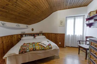a bedroom with a large bed with a wooden ceiling at Spazioso appartamento centrale con wi-fi in Cortina dʼAmpezzo