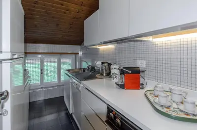 a kitchen with white appliances and a counter top at Spazioso appartamento centrale con wi-fi in Cortina dʼAmpezzo