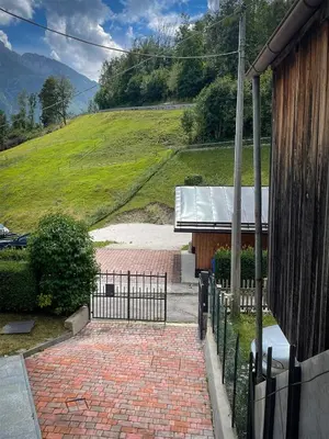 a brick walkway leading to a house with a fence at Busc De Crodol in Comune Rivamonte Agordino