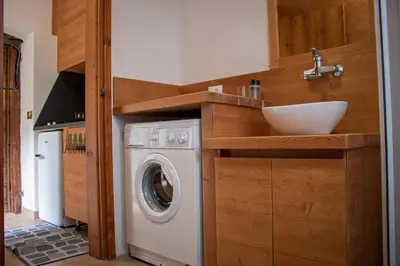 a kitchen with a washing machine and a sink at Busc De Crodol in Comune Rivamonte Agordino