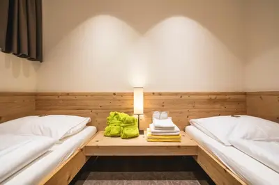 a room with two beds and a table with towels at Residence Der Heinrichshof in Lagundo
