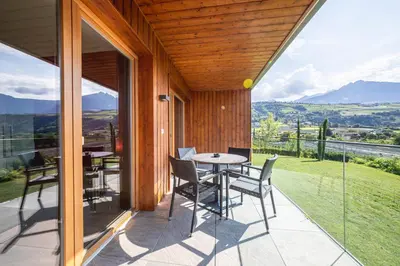 a patio with a table and chairs on a balcony at Residence Der Heinrichshof in Lagundo