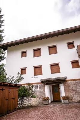 a white building with brown windows at Sorapis Mini - Monolocale Panoramico in Cortina dʼAmpezzo