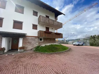 a building with a car parked in front of it at Sorapis Mini - Monolocale Panoramico in Cortina dʼAmpezzo