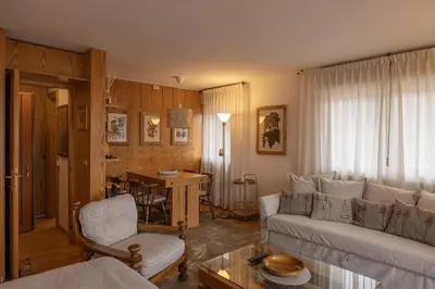 a living room with a couch and a table at Sorapis Mini - Monolocale Panoramico in Cortina dʼAmpezzo