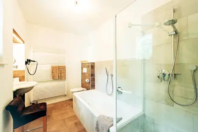a bathroom with a shower and a tub and a sink at Gschnoferhof Terlan in Terlano