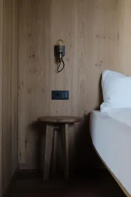 a small table next to a bed and a lamp at Kaiserau-Höfl in Bolzano