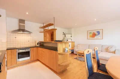 a kitchen and living room with a table and a couch at Apartment Christian in Nova Levante