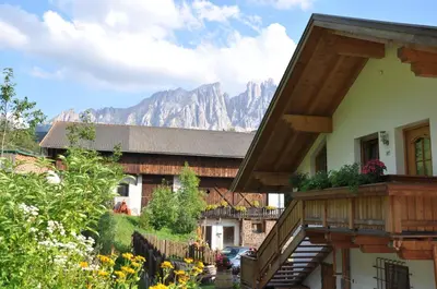 a house with a balcony with mountains in the background at Apartment Christian in Nova Levante