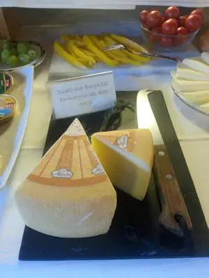 a plate with cheese and a knife and other foods at Apartment Christian in Nova Levante