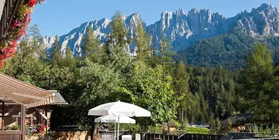 a white umbrella sitting in front of a mountain at Apartment Christian in Nova Levante