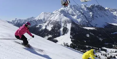 two people are skiing down a snow covered mountain at Apartment Christian in Nova Levante
