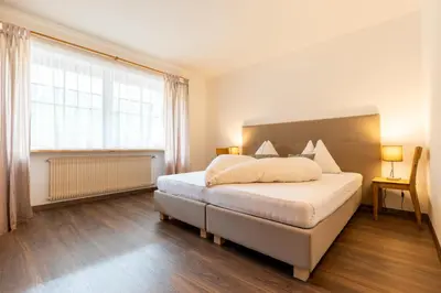 a bedroom with a large bed and a large window at Apartment Christian in Nova Levante