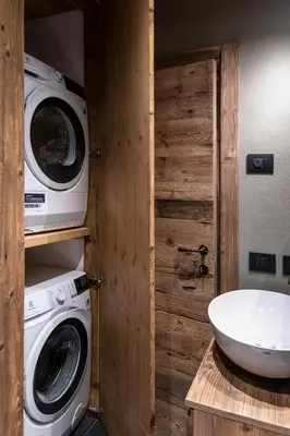 a bathroom with a washing machine and a sink at Cortina Center House in Cortina dʼAmpezzo