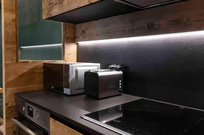 a kitchen with a microwave and a toaster on a counter at Cortina Center House in Cortina dʼAmpezzo