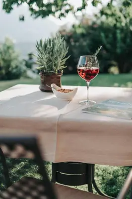 a glass of wine sitting on a table at Hotel Garni Katnau in Schenna