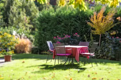 a table and chairs sitting in the grass at Hotel Garni Katnau in Schenna