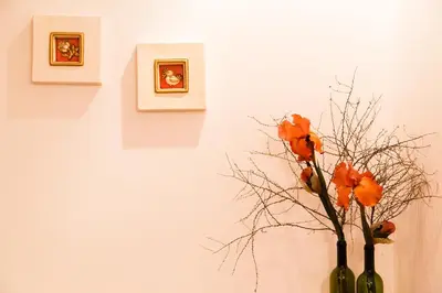 a vase with orange flowers in it next to a wall at Hotel Garni Katnau in Schenna