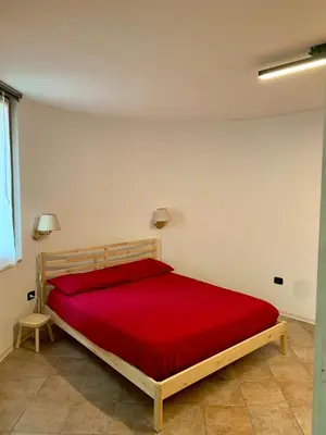 a bedroom with a bed with a red blanket at Pragma Apartments - Appartamento La Torre in Predazzo