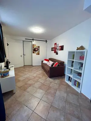a living room with a couch and a book shelf at Pragma Apartments - Appartamento La Torre in Predazzo