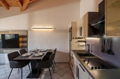 a kitchen with a table with chairs and a dining room at Ferienwohnungen Gamper in Tesimo