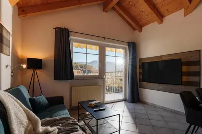 a living room with a couch and a tv at Ferienwohnungen Gamper in Tesimo