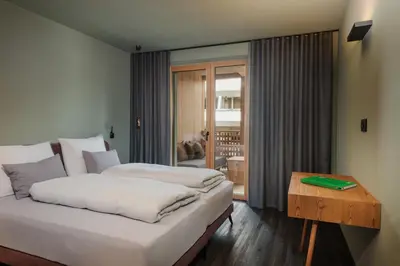 a hotel room with two beds and a table at Max Green Forest Apartments in Siusi