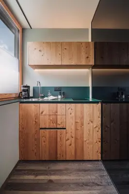 a kitchen with wooden cabinets and a sink at Max Green Forest Apartments in Siusi